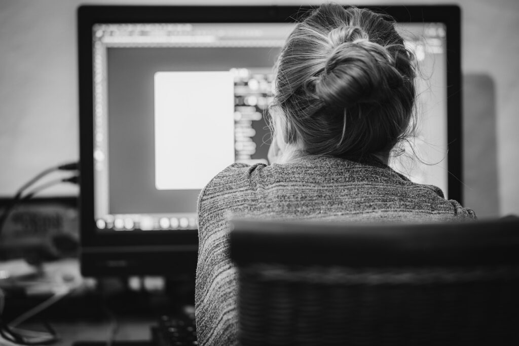 Imagen de una persona sentada trabajando en su computadora, teniendo los beneficios del trabajo remoto o teletrabajo